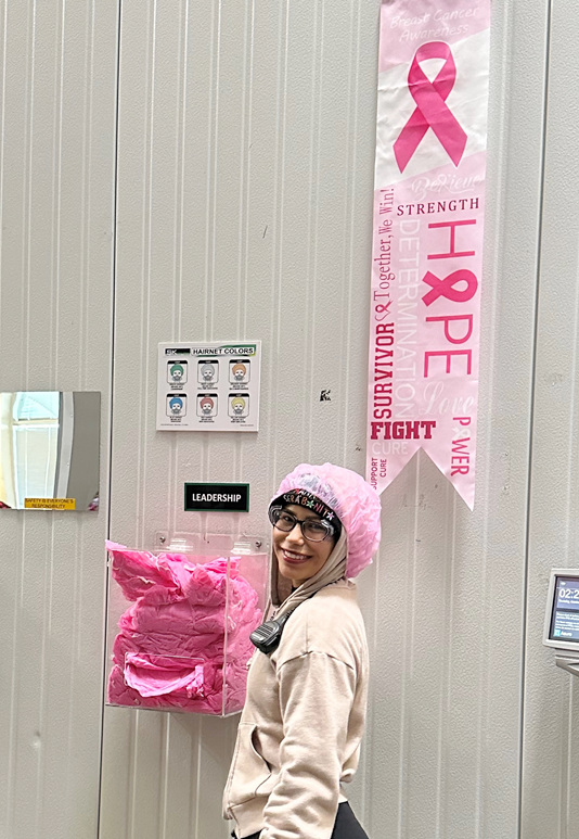 Woman with pink hairnets and Breast Cancer Awareness banner