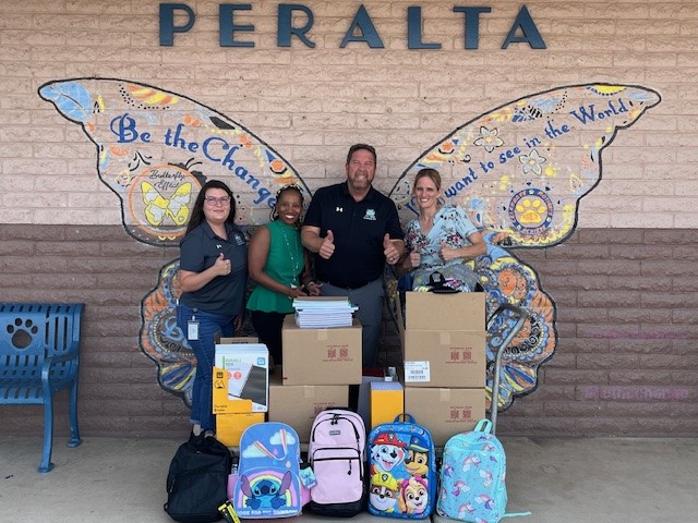Sk Employees in front of Peralta Elementary for a school drive